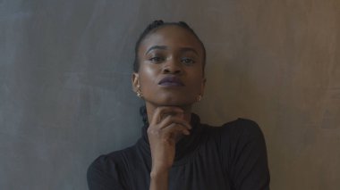Kendine güvenen Afro-Amerikan kadın elini, gri arka plan üzerine yaslanmış. Duygular. Portre.
