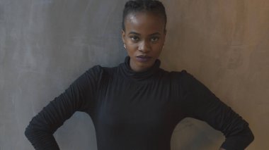 Portre ciddi sakin Afrikalı kız eller bir kenara gri arka plan duvar makyaj tutmak kamera seyir çekici yukarıya kapatmak.