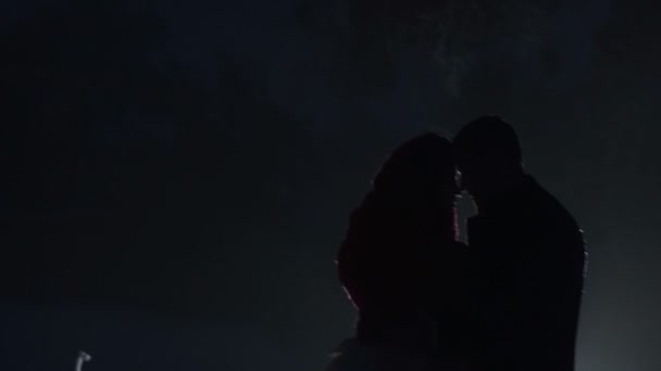 Le silhouette degli sposi in piedi testa a testa e dolcemente baciare di notte. Donna è avvolto in sciarpa lavorata a maglia. Ritratto laterale sensuale . — Video Stock