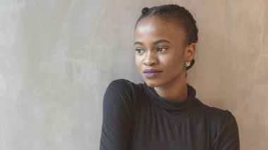 Hassas bir kenara izole duvara bakarak mor ruj ile ihale Afrikalı kız portresi.