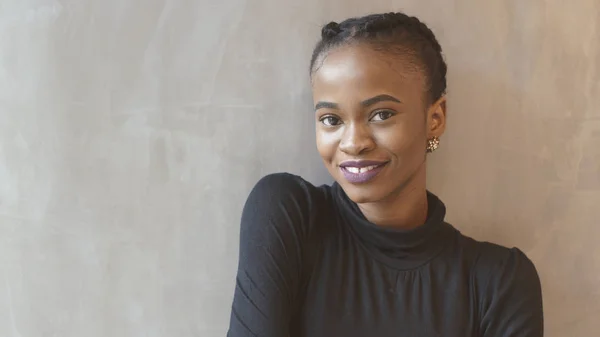 Menina africana encantadora com sorriso atraente está olhando na câmera para o fundo isolado . — Fotografia de Stock