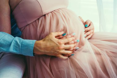 Yakından görmek üst mide içinde şık pembe hamile kadın dokunmadan eller. Yüzü olmayan.