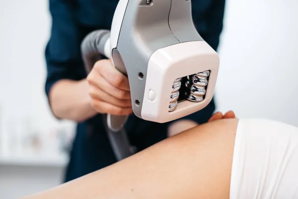 Ultrason kavitasyon makinesi Şevval Özçelik Güzellik elinde. Yakın çekim görünümü. Kadın anti-selülit tedavisi görüyor. Vücut şekillendirme. Yüzü olmayan.