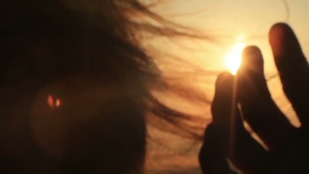 Mannenhand silhouet is zachtjes aanraken van het verplaatsen van wind vrouw haargroei tijdens de zonsondergang. — Stockvideo