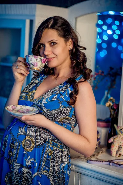 집에서 차 한잔 들고 검은 곱슬 머리와 귀여운 젊은 행복 한 임신 여자의 초상화. — 스톡 사진