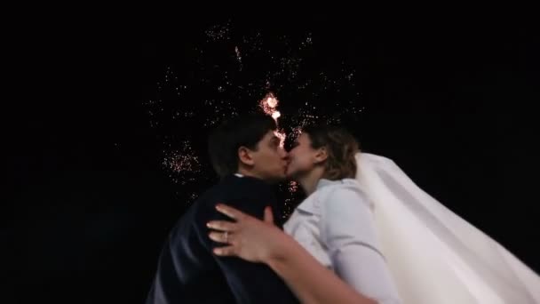 Retrato de cerca de los recién casados besándose en el fondo de los fuegos artificiales . — Vídeos de Stock