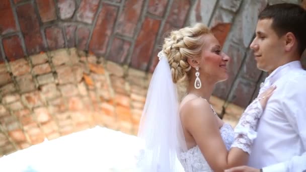 Close-up side portrait of the smiling kissing newlywed couple. Outside portrait. — Stock Video