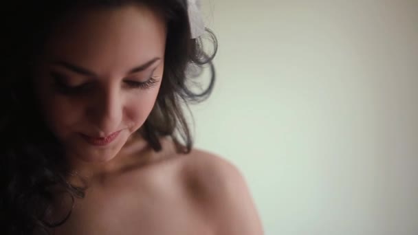 Mattina della sposa bruna incantevole con capelli ricci nell'abito da sposa elegante decorato con brillantini. Telecamera abbassata. Ritratto ravvicinato . — Video Stock