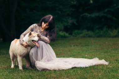 Güzel genç esmer uzun Abiye yumuşak çayır üzerinde onun sevimli zencefil kabarık dış yapraklar sevişme içinde yatay portresi.