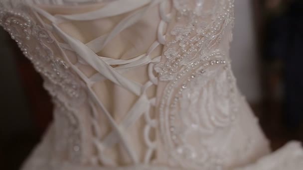 La vista de cerca de la parte posterior del vestido de novia con corsé decorado con cuentas y destellos . — Vídeos de Stock