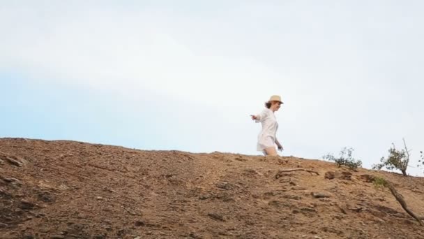 Close-up view from drone on the cheerful woman running along the rock. Tourism concept. — Stock Video