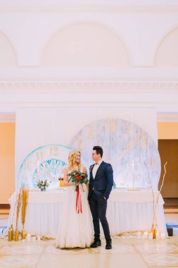 Mutlu genç Düğün çifti restoranda gül buketi ile poz. 