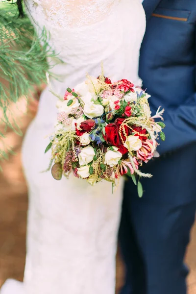 新郎の手にカラフルな花やハーブからなる素敵な結婚式の花束のクローズアップビュー. — ストック写真