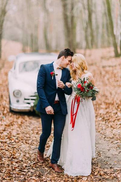 Casal lindo posando perto do carro na floresta — Fotografia de Stock