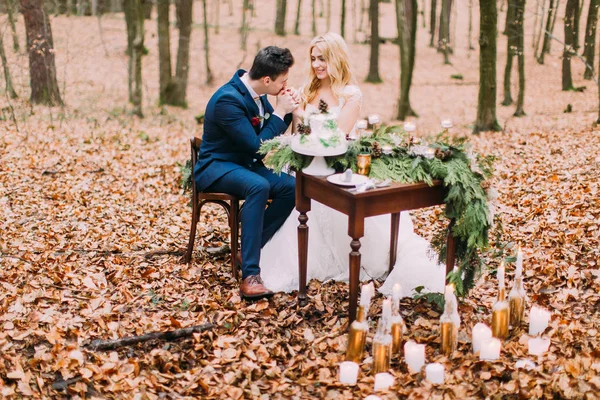 Casal bonito sentado na mesa vintage na floresta de outono — Fotografia de Stock