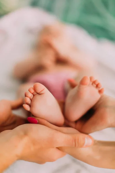 Os pais estão segurando os pés de seu bebê. Vista de perto . — Fotografia de Stock