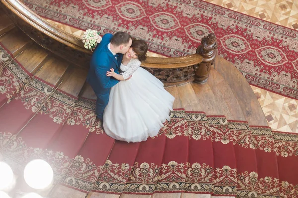 Foto para baixo do noivo está beijando a noiva na bochecha enquanto está de pé nas escadas . — Fotografia de Stock