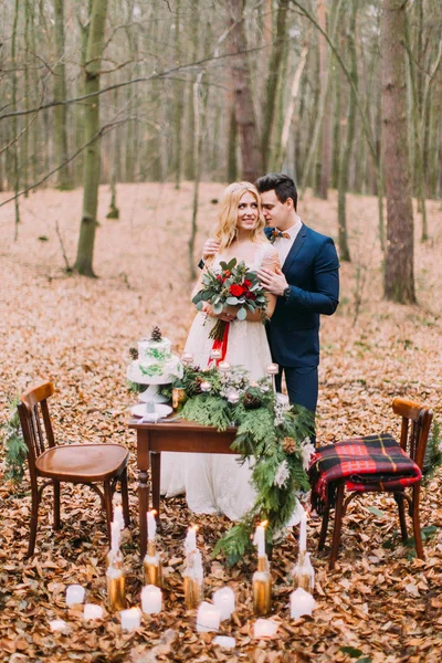 Casal bonito posando perto da mesa vintage na floresta de outono — Fotografia de Stock