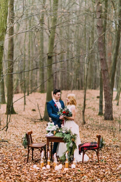 Casal bonito posando perto da mesa vintage na floresta de outono — Fotografia de Stock