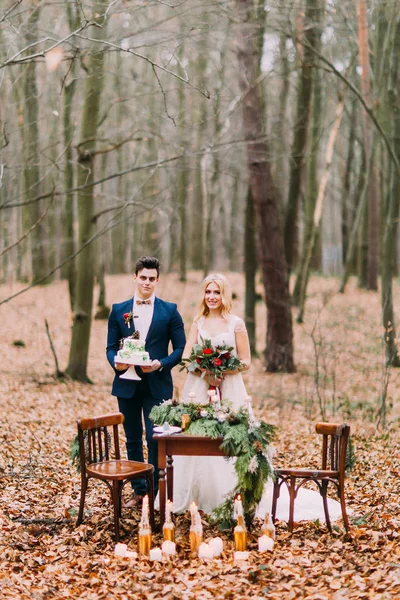 Beau couple de mariage posant près de la table vintage dans la forêt d'automne — Photo