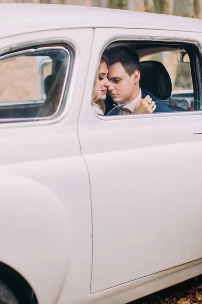 Feliz recién casados en coche vintage blanco de cerca — Foto de Stock