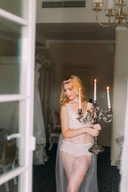  Eski Pyres tutan başındaki beyaz iç çamaşırı ve elmas diadem içinde seksi sarışın gelin. Lüks daireler arka plan