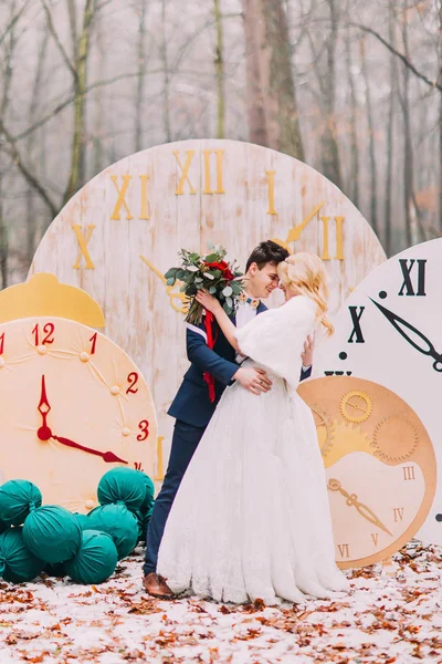 Casal feliz abraça suavemente os grandes relógios vintage na floresta de outono. Decorações criativas — Fotografia de Stock