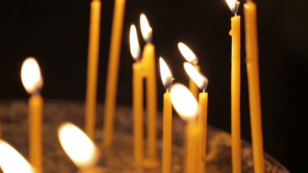 Le candele accese sullo sfondo nero. Nessuno. Foorage da primo piano. Spostamento verso l'alto . — Video Stock