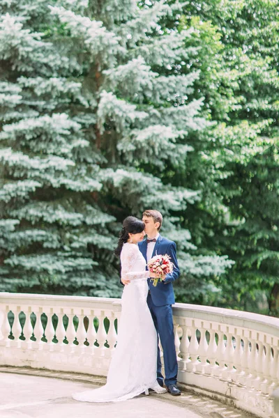 Der Bräutigam küsst der Braut auf den Kopf. die Ansicht im Freien in voller Länge. — Stockfoto