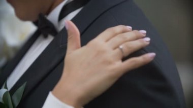 Gelin el şefkatle damadın omzuna dokunuyor. Yakın çekim görünümü. Hiçbir yüzler.