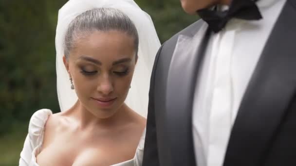 Portrait sensible de la belle mariée brune attrayante appuyée sur l'épaule du marié et regardant à la caméra . — Video