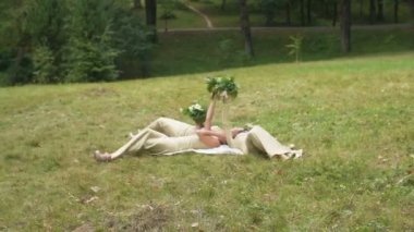 Üç genç çekici nedime uzun elbiseler yeşil çayır on yalan süre kadar beyaz buketleri tutuyorsun.