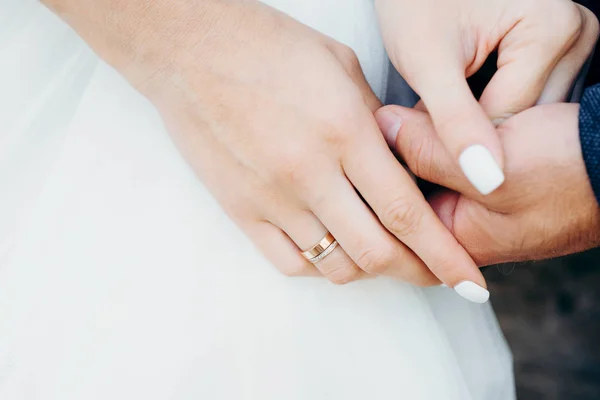 Close-up beeld van de pasgetrouwden zachtjes hand in hand. — Stockfoto