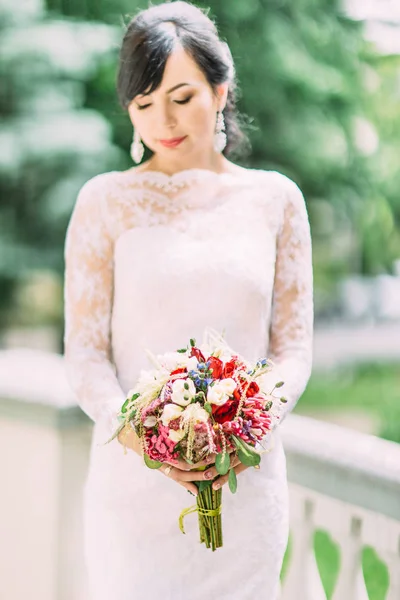 El colorido ramo de bodas celebrado por la novia en el fondo borroso . — Foto de Stock