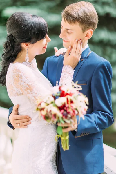 Närbild sida porträttet av bruden smeka kinden av brudgummen. — Stockfoto