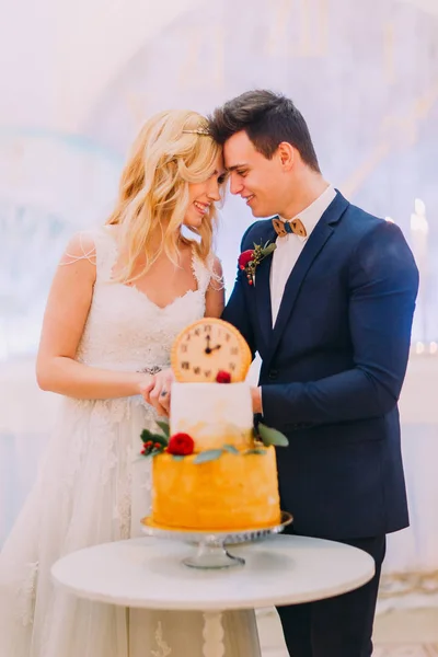 Belle mariée blonde et marié couper le gâteau de mariage ensemble — Photo