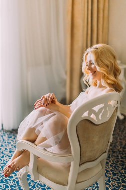 Koltukta oturan ve gülümseyen sevimli sarışın gelin. Lüks daireler arka plan