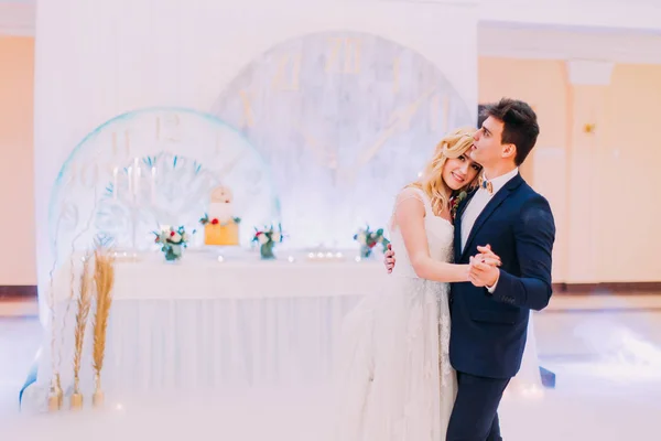 Feliz jovem noiva e noivo dançam no salão de casamento — Fotografia de Stock