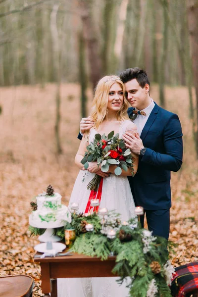 Beau couple de mariage posant près de la table vintage dans la forêt d'automne — Photo