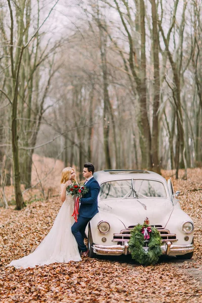 Beau couple de mariage posant près de la voiture en forêt — Photo