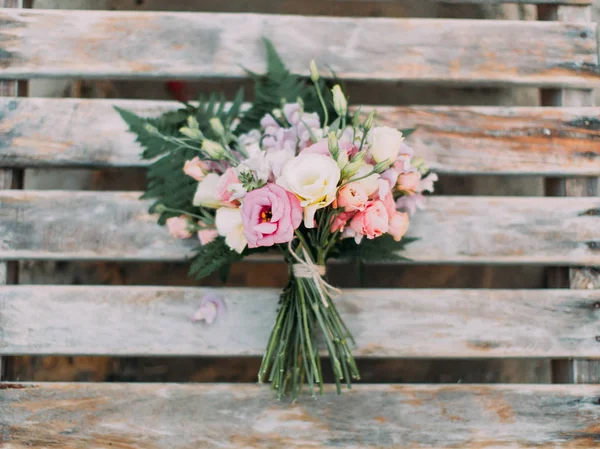 Горизонтальний портрет прекрасного весільного букета з різнокольорових троянд, розміщених на дерев'яному тлі . — стокове фото