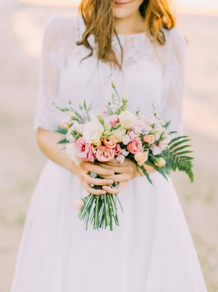 Il mazzo di nozze consisteva delle rose rosa, bianche e gialle tenute dalla sposa . — Foto Stock