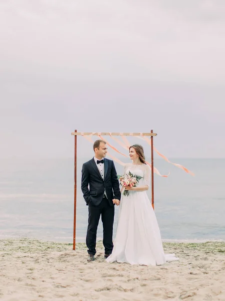 El contacto visual entre los recién casados felices tomados de la mano en el fondo del mar . —  Fotos de Stock