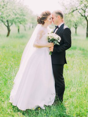 Güzel yeni evliler yeşil parkta kafa kafaya duruyorsun.