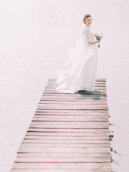 La sposa è in piedi alla fine del molo . — Foto Stock