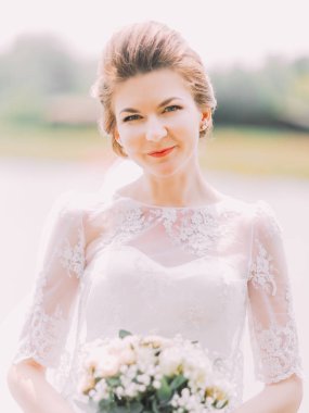 Nehrin arka plan beyaz buket gül tutan gelin yakın çekim portresi.