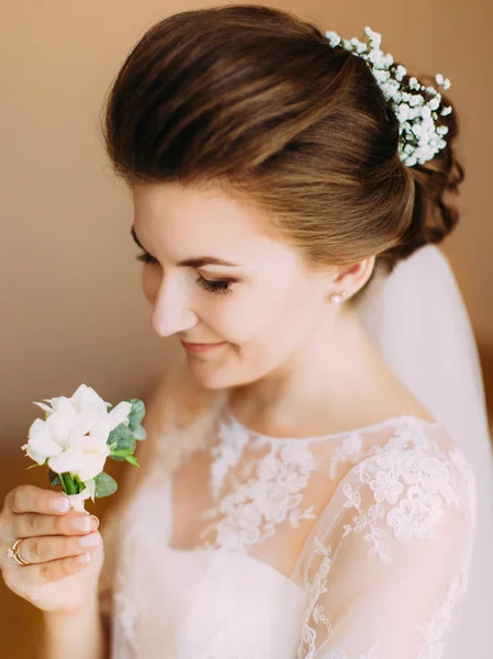 La sposa sta guardando il mini-bouquet bianco. Ritratto con primo piano laterale . — Foto Stock