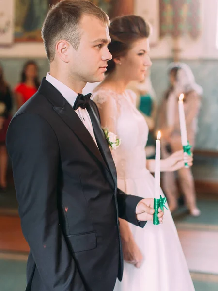 結婚式中にキャンドルを保持している新婚の側面図. — ストック写真