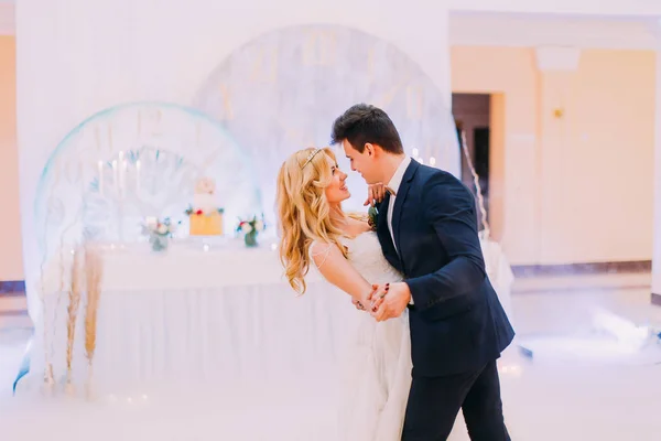 Feliz jovem noiva e noivo dançam no salão de casamento — Fotografia de Stock