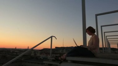 Şehir Köprüsü batımında dizüstü tutan genç şık iş kadın silüeti